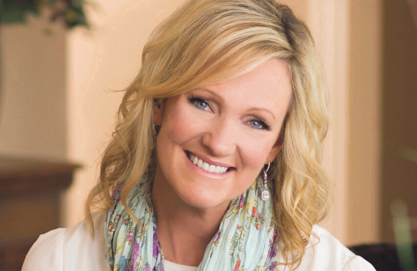 Bilde av forfatter Karen Kingsbury. Hun smiler og er ikledd hvit bluse og et turkis skjerf